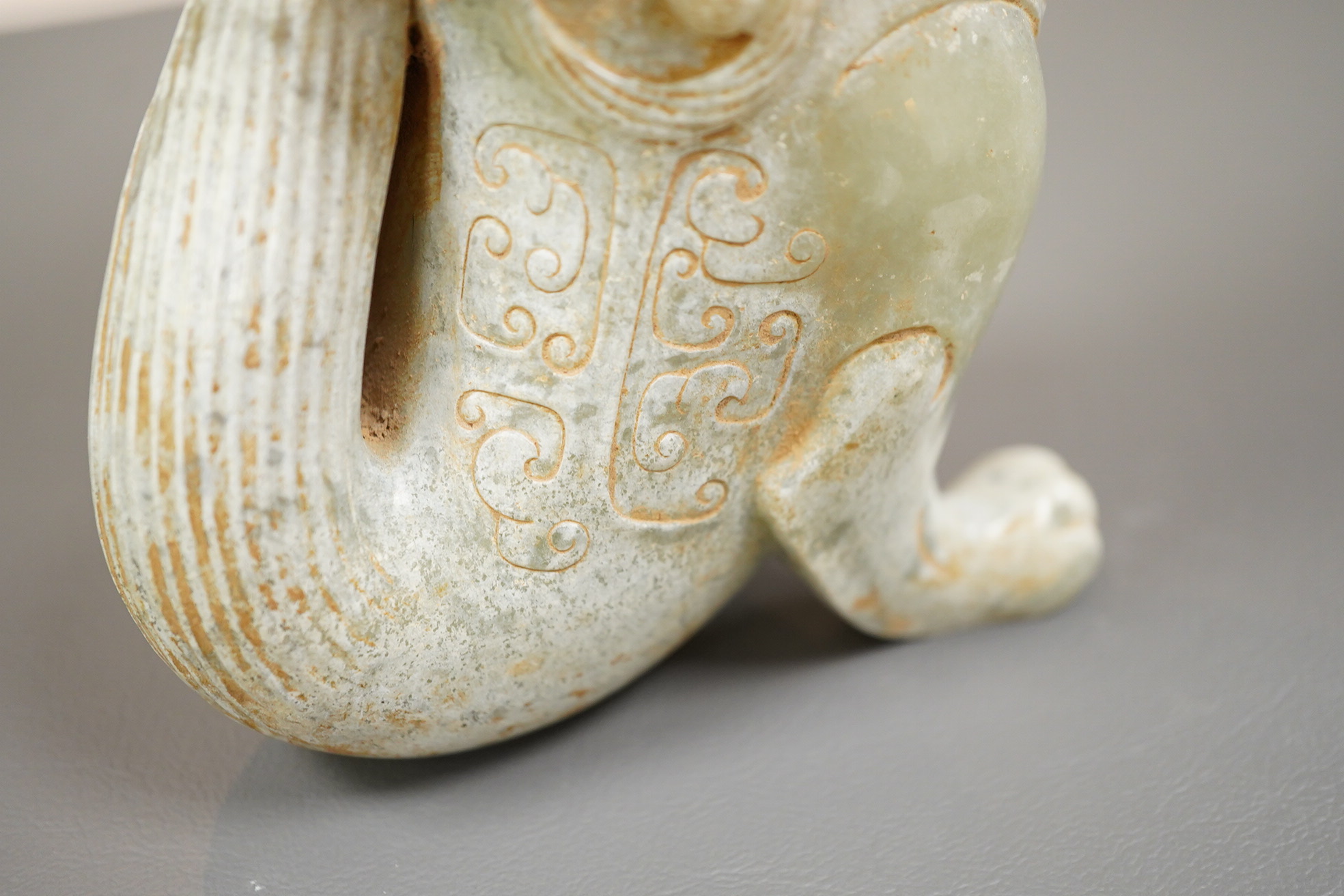 A large Chinese archaistic pale celadon and calcified jade rhyton
